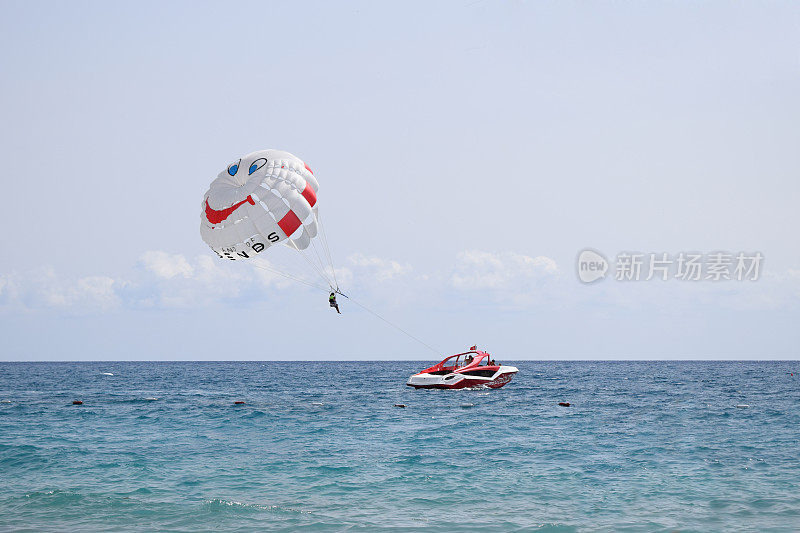 一艘船拉着有趣的滑翔伞翼。夏季休闲。夏季水滩极限运动。