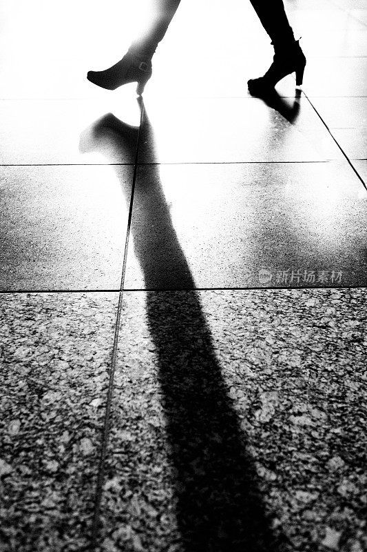 一个穿长筒靴的女人走路的剪影