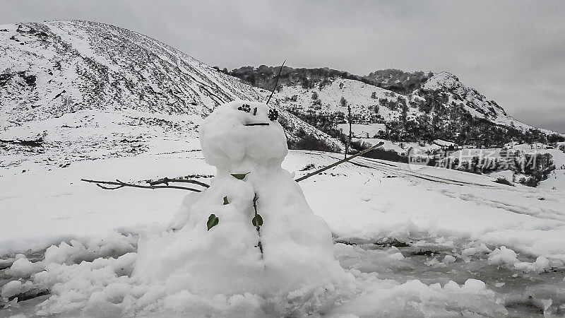 以雪山为背景的雪人。