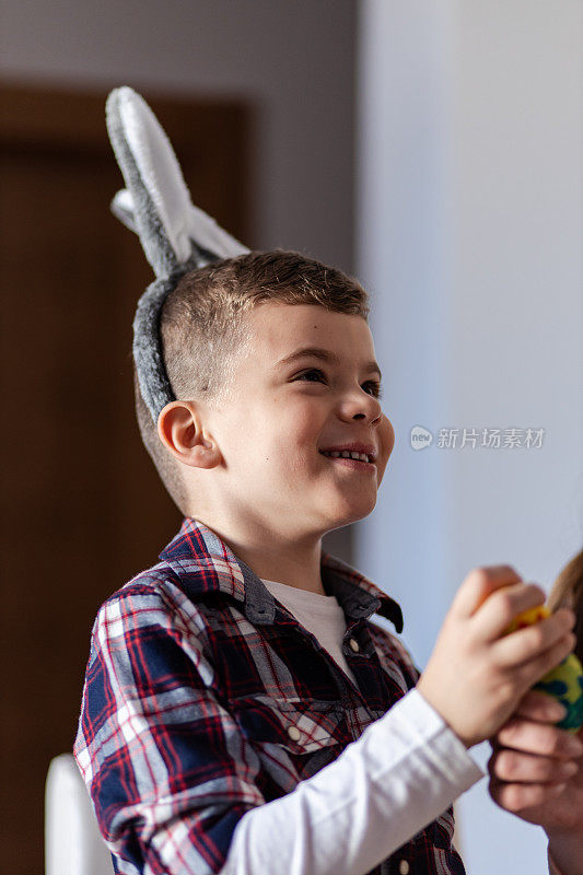 快乐的小男孩微笑着戴着复活节兔子耳朵