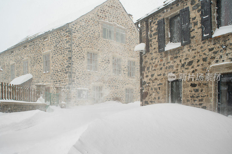 暴风雪中村庄里的石头房子