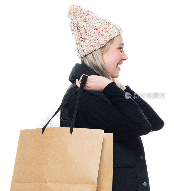 白人女性购物狂在白色背景前穿着裤子，拿着包