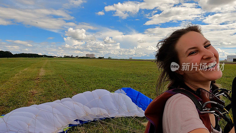 一个穿着休闲服装微笑的女跳伞者的照片