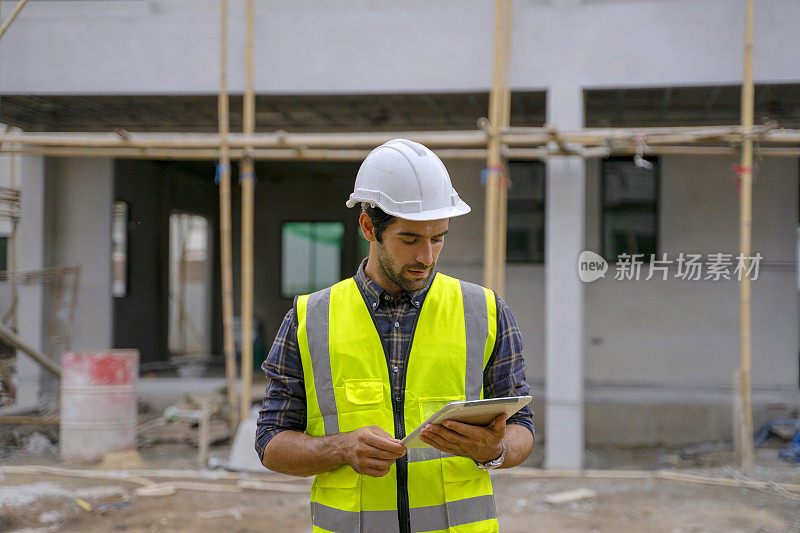 蓝领工人在建筑工地与同事一起工作。