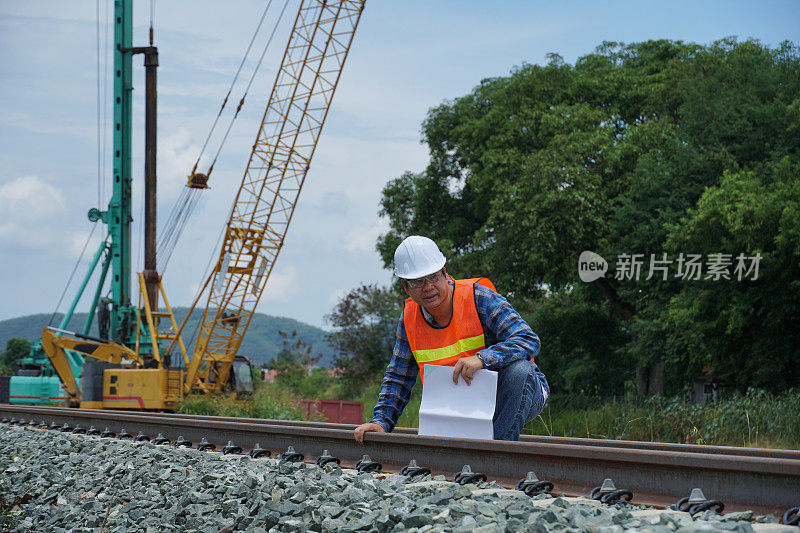 亚洲工程师在外面检查修建一条高速铁路。