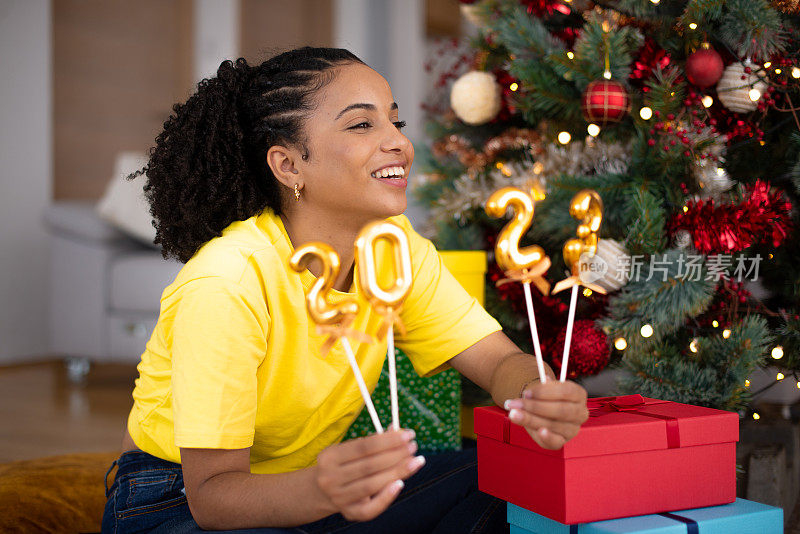 快乐的女人在家里庆祝新年库存照片