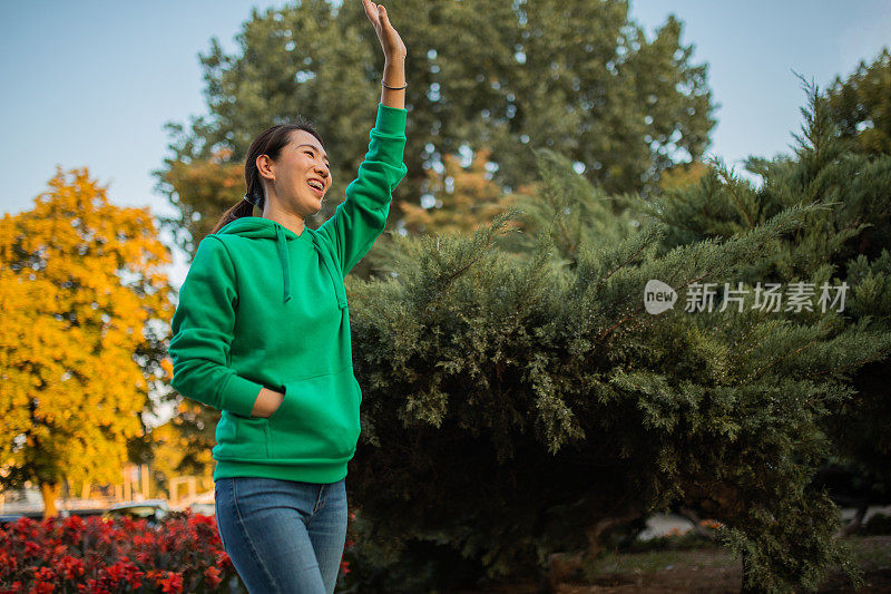 一名中年日本妇女向一名朋友招手