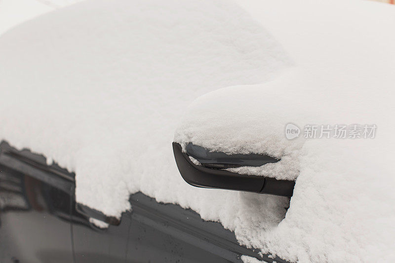 汽车镜子特写。雪下的汽车。冬天的天气。气候。风暴。运输