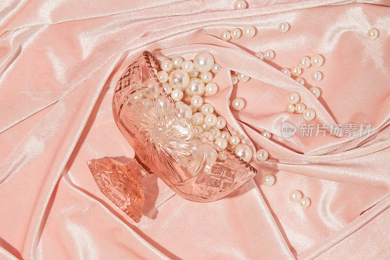 浪漫的创意布局与水晶碗和泼珍珠粉彩粉红色天鹅绒背景。八九十年代复古时尚的审美爱的概念。极简浪漫的想法。