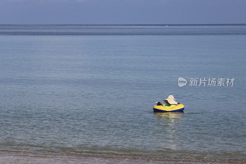 一名女子在海洋中的充气圈上游泳