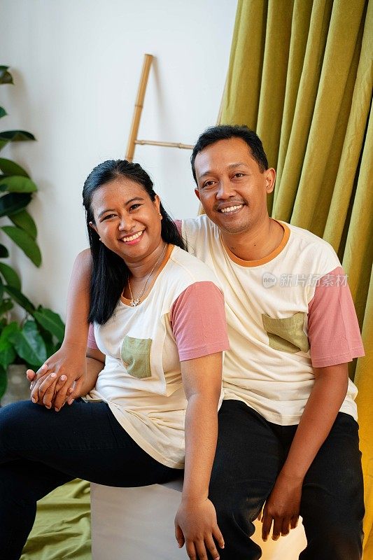 年轻的印度尼西亚夫妇家庭的快乐工作室肖像