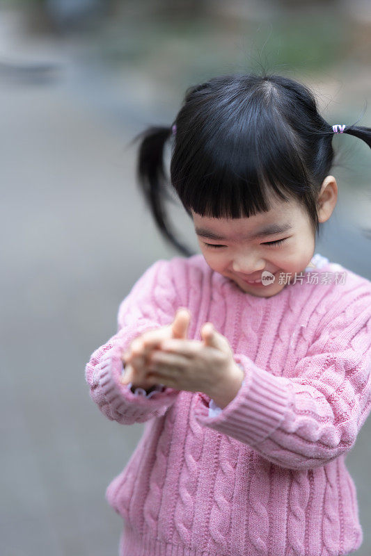 可爱的亚洲小女孩，儿童肖像照片，在公园里快乐地玩耍