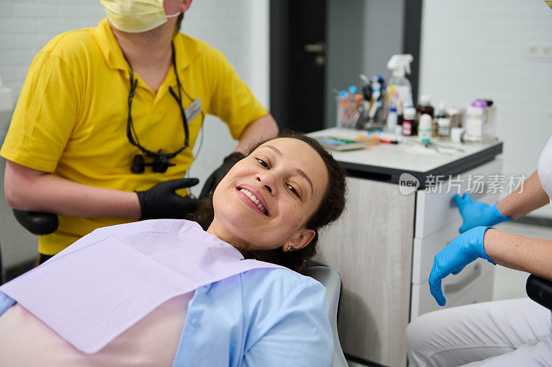 孕妇牙科治疗。孕妇在牙科诊所接受牙医检查，对着镜头微笑