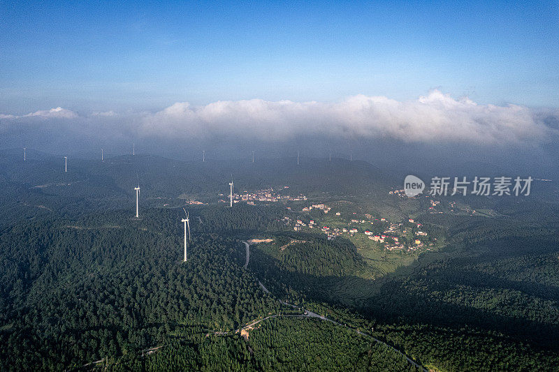 风力涡轮机和阳光山上的村庄