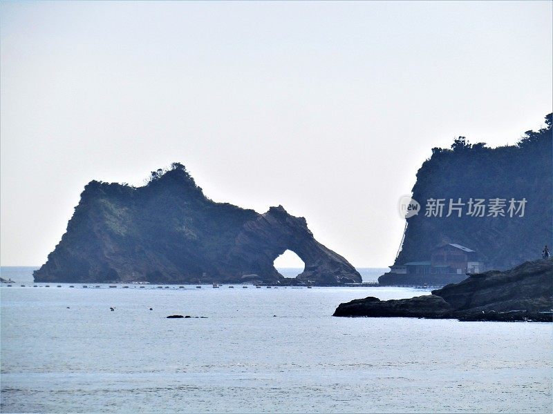 日本。岩石在海里有一个圆洞。