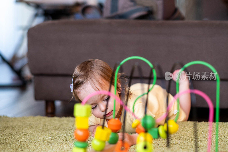 一个小女孩正在玩一个玩具迷宫