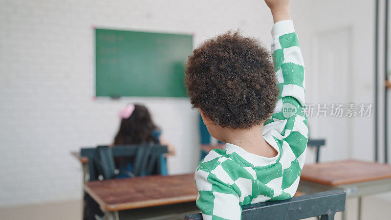 非裔美国男生在课堂上讲课时举手提问。男生在学校课堂上举手回答老师提问。教育知识观
