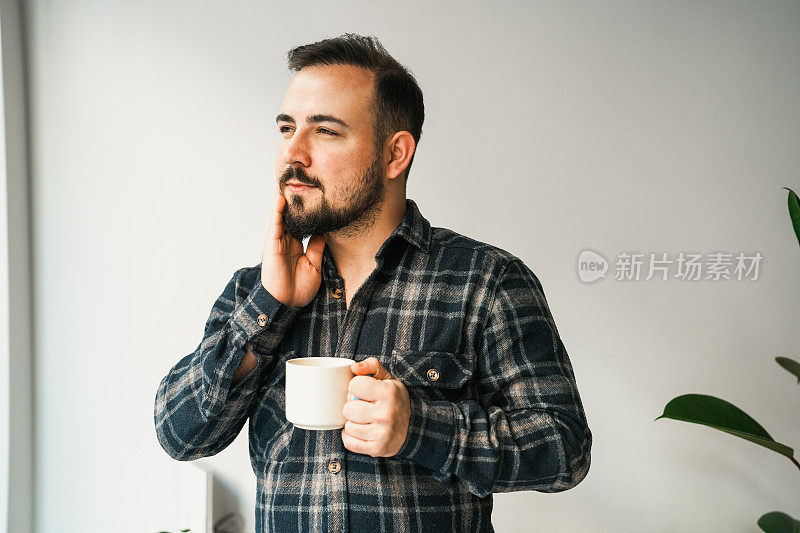 牙痛的男人用手在白色背景前捂着脸颊