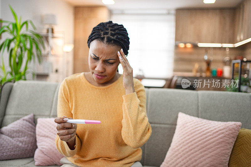 黑人妇女在家里对验孕结果感到不高兴