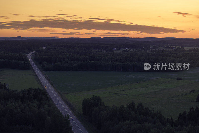 夏日夜晚，从空中俯瞰公路穿过乡村风景