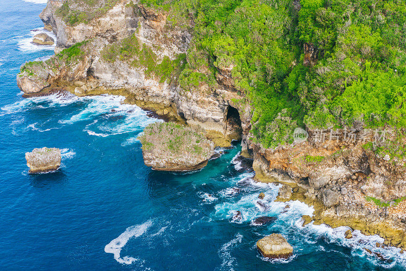 巴厘岛，武吉岛-鸟瞰图崎岖的绿色悬崖和绿松石海，天然岩层和海浪撞击。