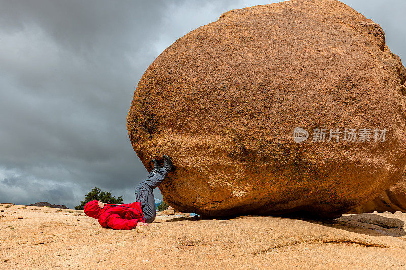 北非摩洛哥反阿特拉斯山脉的Tafraoute，男性在棕色的岩石上猛冲