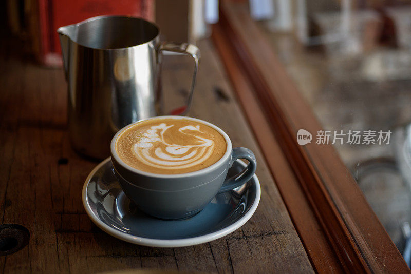 咖啡和天鹅形状的泡沫艺术在木桌上