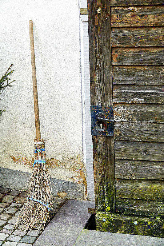 稻草扫帚在房子的墙上
