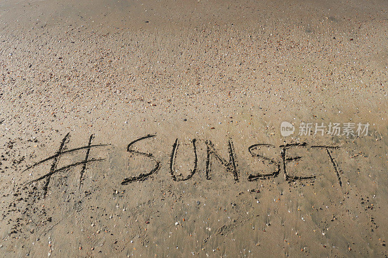 图片的标签标签写在阳光明媚的海滩上，日落的单词写在沙滩上，Palolem海滩，印度果阿，概念社交媒体照片的手写在金色的沙子与现代标签前缀