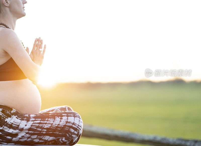 孕妇在日落时冥想