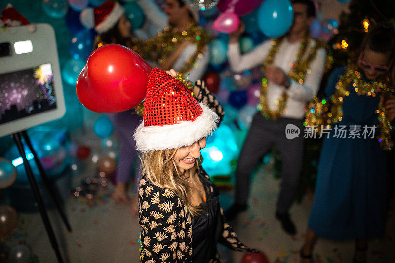美丽的年轻女子跳舞，并与她的朋友在新年除夕晚会上玩得开心