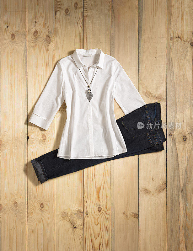 时尚的白色衬衫和蓝色牛仔裤孤立的木材背景
