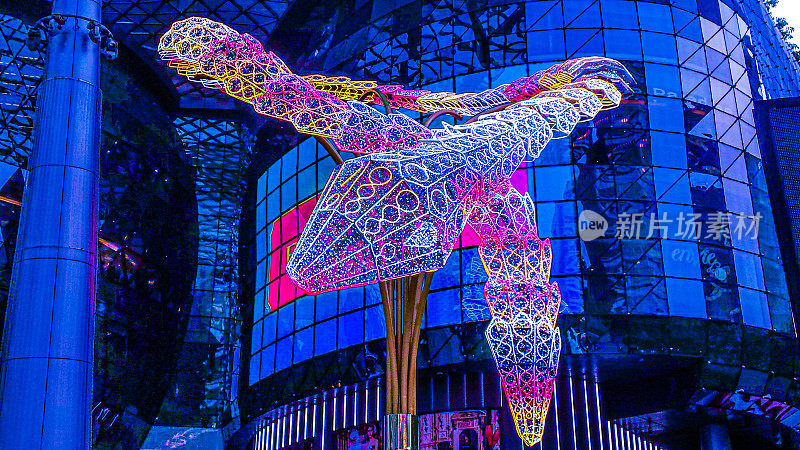 在新加坡，一个巨大的现代蜗牛或龙雕塑，以彩色的灯光装饰