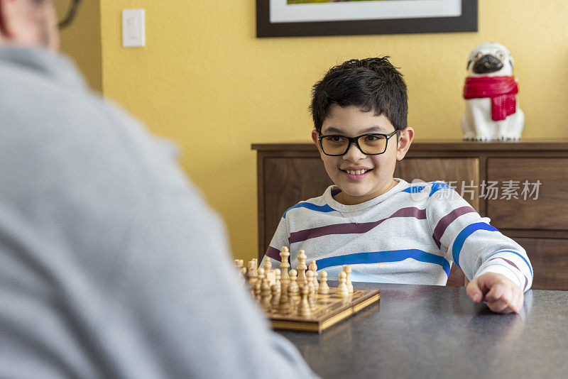 爸爸和孩子在家里下棋