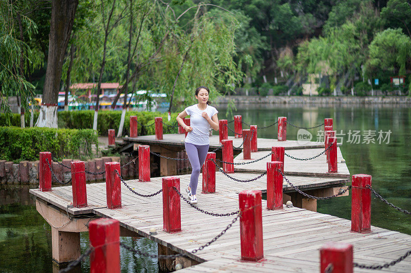 年轻的亚洲女人在城市公园里练瑜伽