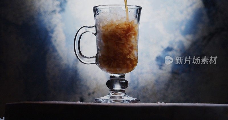 把冷咖啡倒进爱尔兰玻璃杯里，杯子里满是碎冰