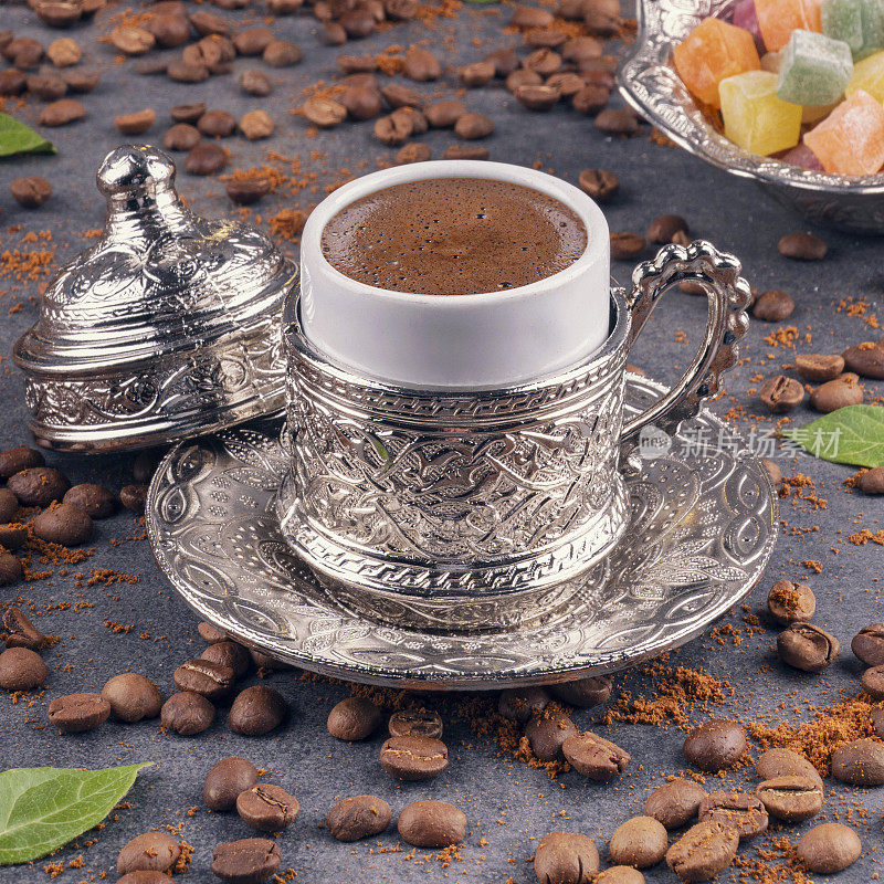 土耳其咖啡和土耳其软糖与传统压花金属托盘和杯子。传统咖啡的概念。传统的土耳其咖啡和土耳其软糖以黑咖啡豆为背景。