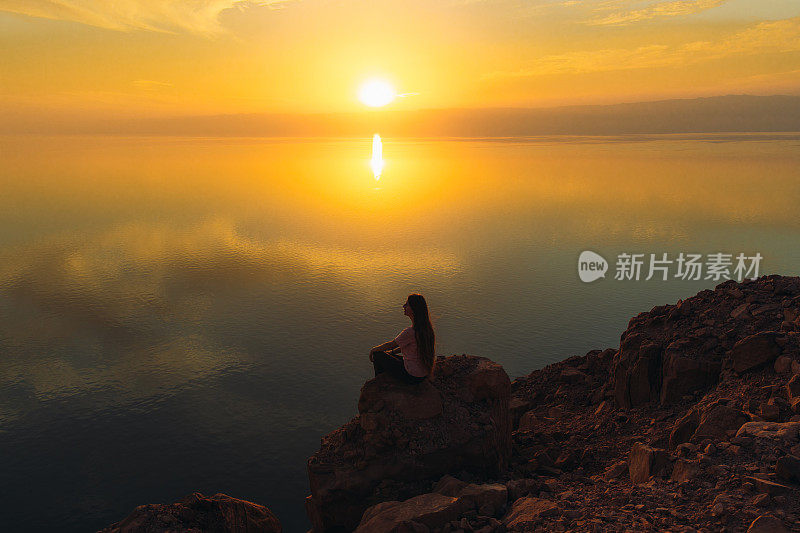 约旦死海上一个女人的剪影，她正在欣赏日落美景