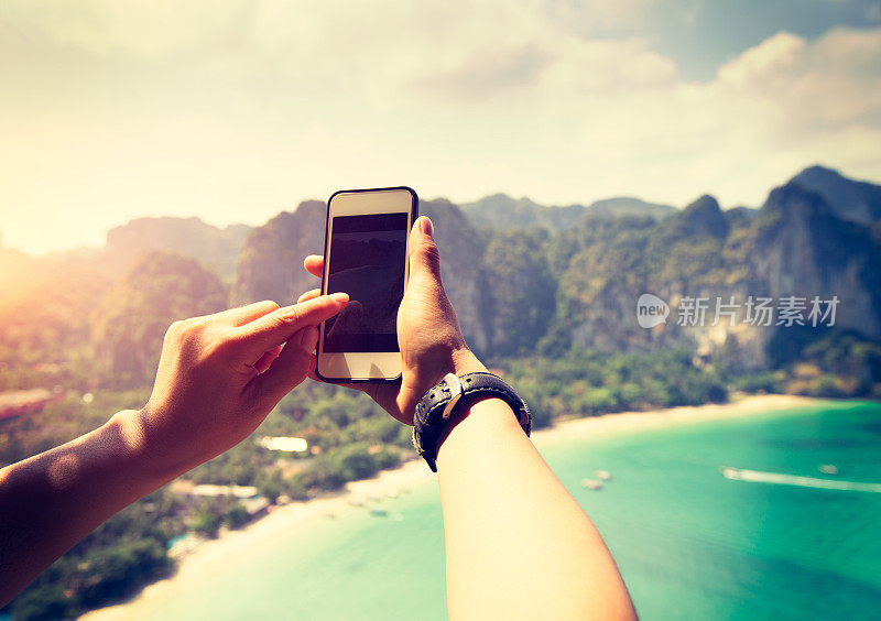 在海边用智能手机拍照