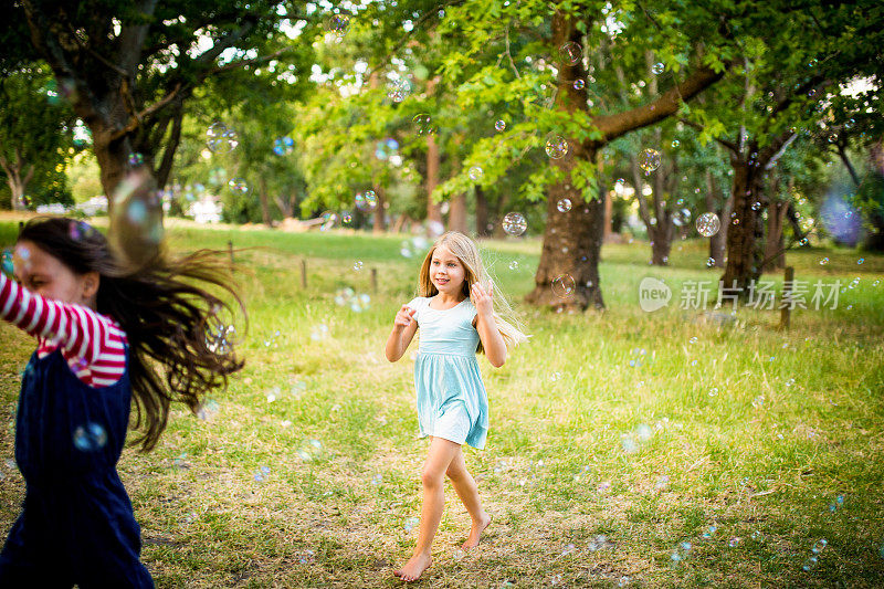 友善的小女孩在公园里追逐和奔跑