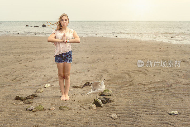 健康女孩做放松在海滩上的鸟。