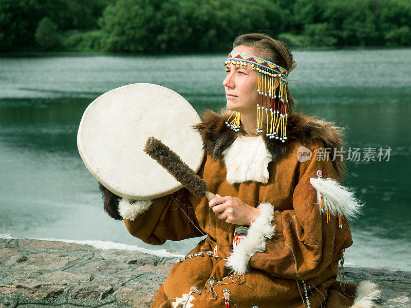 成年妇女穿着传统的科利亚克服装，手持小手鼓