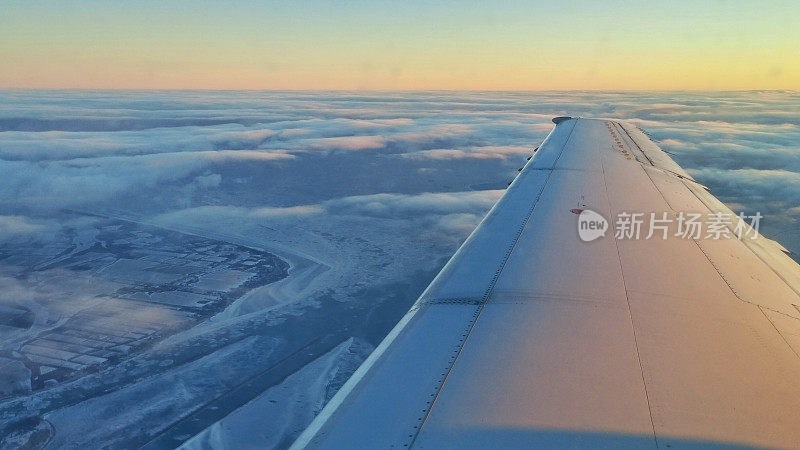 柔和的早晨日出天空与飞机机翼，冬天，雪