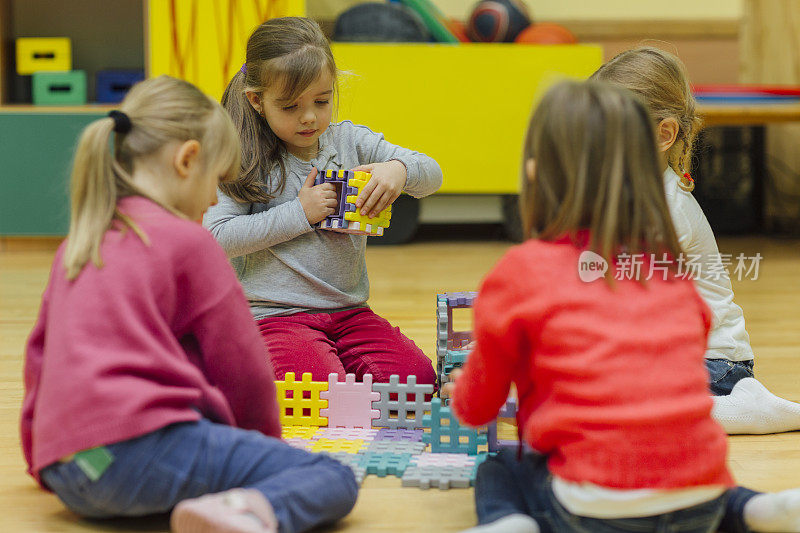 幼儿园里玩积木的可爱女孩