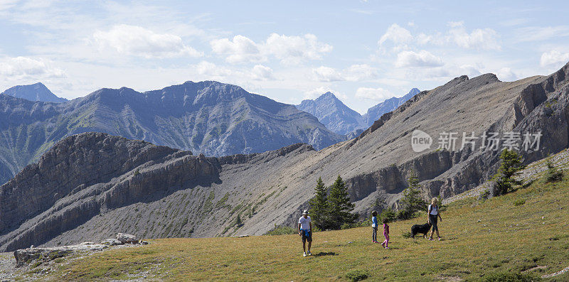 一家人走在高山、山谷的山坡上