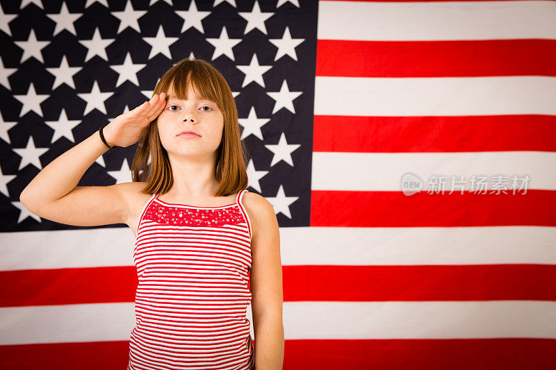 小女孩在美国国旗前敬礼