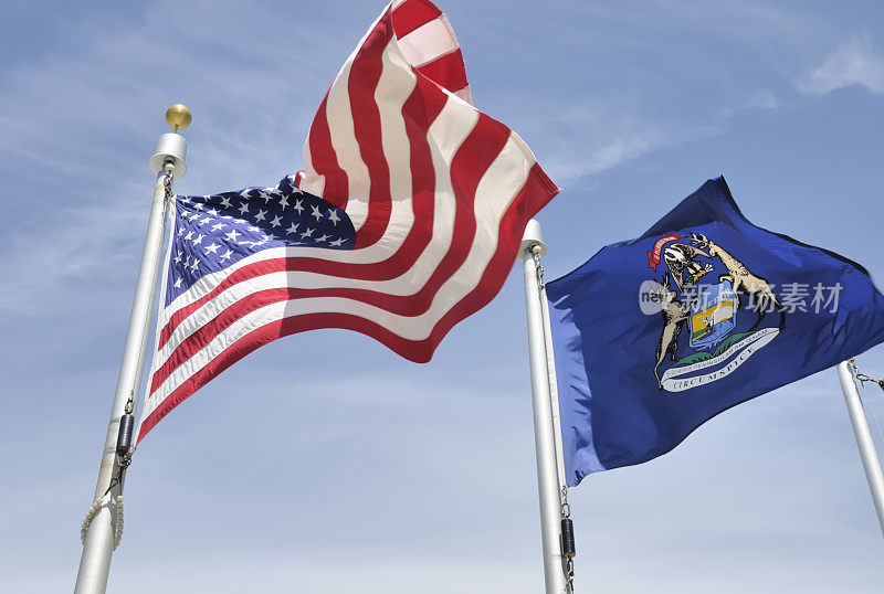 美国和密歇根州的旗杆在空中飘扬。