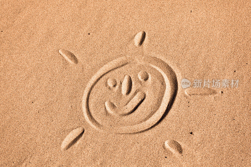 微笑的太阳脸在沙子里画
