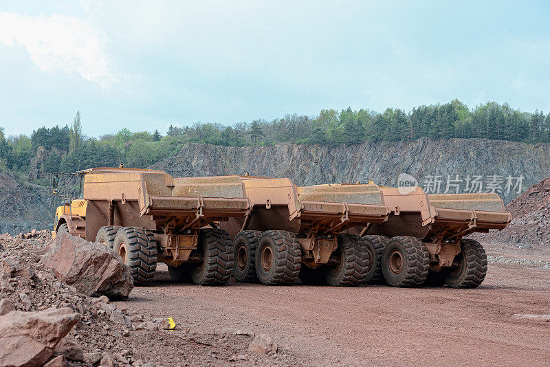 三辆自卸卡车在采石场排成一排。采矿行业。
