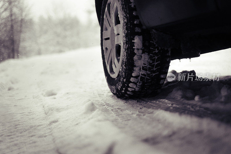 近距离的汽车冬季轮胎在雪